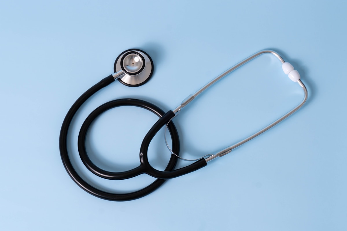 Simple stethoscope on a pastel blue background.