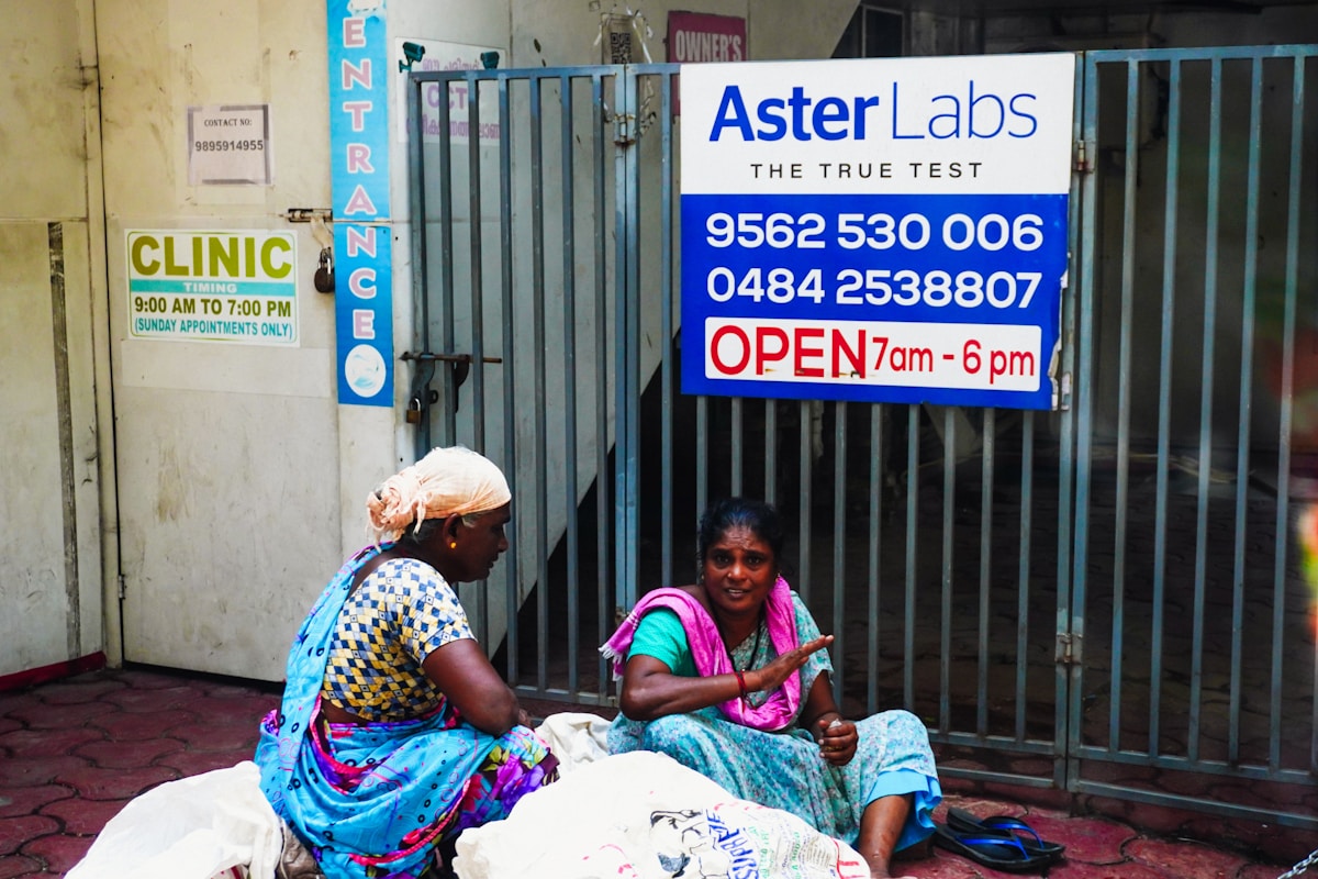 Two women sitting outside a clinic entrance