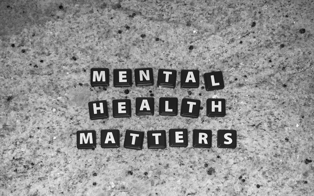 Black letter tiles spelling Mental Health Matters on a speckled grey stone surface